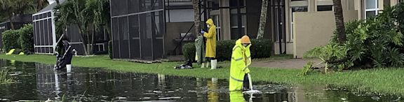 Des personnes nettoient le sol dans la rue après une inondation